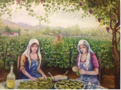 Zwei Frauen vor Feld rollen Weinblätter am Tisch